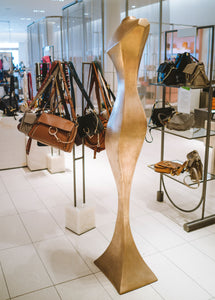 Side view of contemporary cast bronze Female Form sculpture in a retail store