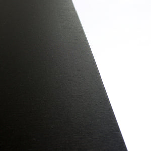 Detail view Lin Bench texture, minimalist curved bench in blackened hot rolled steel