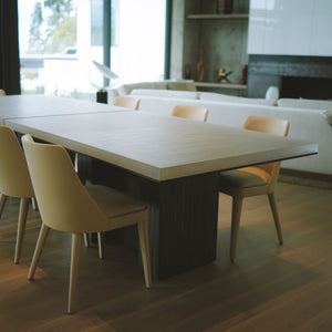 Worzel Table in dining room interior, blackened cast aluminum base with eco resin top 
